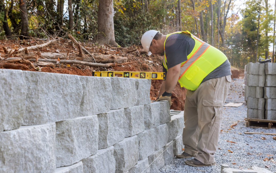 Construction Worker Building A Retaining Block Wall Being Built On New Property